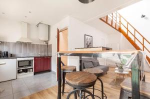 a kitchen with a table and chairs in a room at Le 7 in Sète