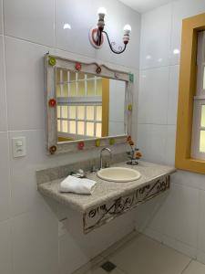 y baño con lavabo y espejo. en Pousada Villa Real, en Tiradentes