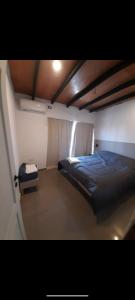 1 dormitorio con cama y ventana. en Casa Nueva en Villa Rumipal