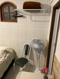 a small room with a fan and a chair at Estúdio ( Kitnet ) confortável in Ouro Preto