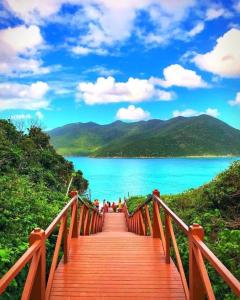 un puente de madera con vistas al agua en Hospedagem do Cabo, en Arraial do Cabo