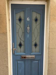 a blue door with a number on it at Sunny Studio with en-suite in Belvedere