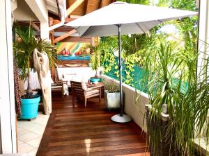 a patio with an umbrella and some plants at Kazasoley in Le Gosier