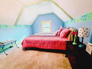 a bedroom with a red bed in a attic at BELLE ON HARLEM - Shared Homestay in Rockford