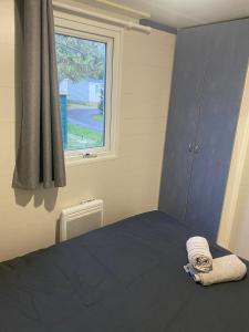 - une chambre avec un lit bleu et une fenêtre dans l'établissement Bungalow 2/4 personnes dans résidence Hôtelière, à Meyzieu