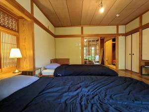 a large bedroom with two beds and a window at Yuzan apartment Sanjo in Nara