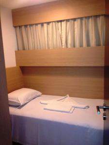 1 dormitorio con 1 cama con cabecero de madera en AP BEACH CLASS FORTALEZA, en Fortaleza