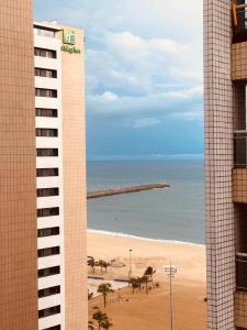 uma vista para a praia a partir de um edifício com uma praia em AP BEACH CLASS FORTALEZA em Fortaleza