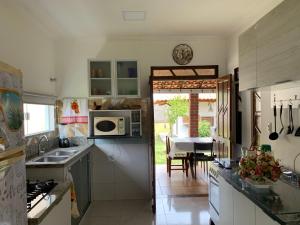 a kitchen with a sink and a table with a dining room at Casa D'Jhú in Vera Cruz de Itaparica