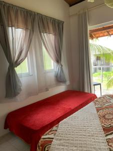 a bedroom with a bed and a window with curtains at Casa D'Jhú in Vera Cruz de Itaparica