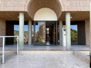 卡洛斯帕斯的住宿－DEPARTAMENTO ROCA，带有柱子和窗户的建筑物入口