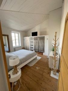 een slaapkamer met een bed en een tafel en een televisie bij House in the center and near the beach in Rivedoux-Plage