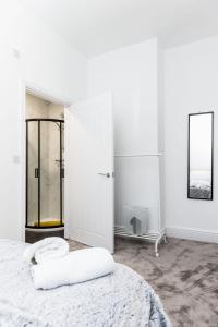 um quarto branco com uma cama e um espelho em Warwick West em Barrow in Furness
