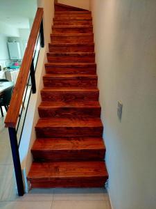 una escalera con escalones de madera en una casa en Departamento playa bonita Bariloche en San Carlos de Bariloche