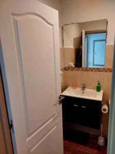 La salle de bains est pourvue d'un lavabo et d'une porte blanche. dans l'établissement Departamento playa bonita Bariloche, à San Carlos de Bariloche