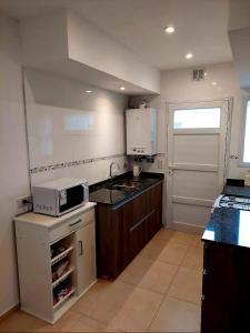 a small kitchen with a sink and a microwave at Departamento playa bonita Bariloche in San Carlos de Bariloche