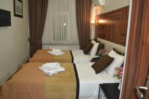 two beds in a hotel room with towels on them at Grand Fatih Hotel in Istanbul