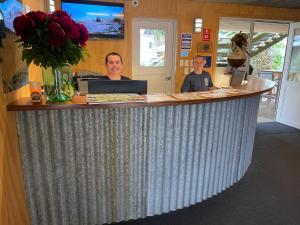 two women standing at a counter in a store at Te Anau Lakefront Backpackers in Te Anau