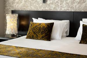 a bed with a black headboard and pillows and a lamp at The Sails Nelson in Nelson