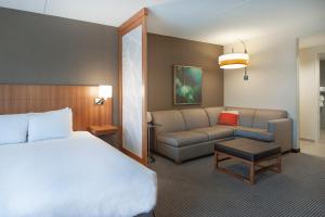 a hotel room with a bed and a couch at Hyatt Place Durham Southpoint in Durham