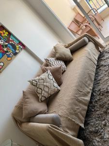 un sofá con almohadas en una habitación en Apartamento Praia do futuro Bech Village, en Fortaleza
