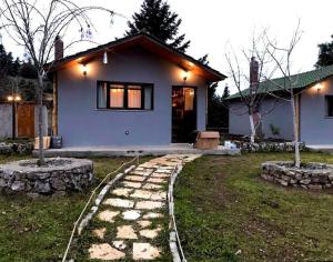 una casa con un sentiero in pietra di fronte a una casa di Νύμφες Σαλέ Καλλιστώ 