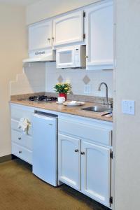 a kitchen with white cabinets and a sink at Old Town Inn in San Diego