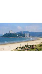 een uitzicht op een strand met gebouwen en de oceaan bij Kitnet em frente à praia in São Vicente