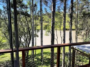 een veranda met een hek en uitzicht op een meer bij Pousada Lago do Amanhecer in Capão Alto