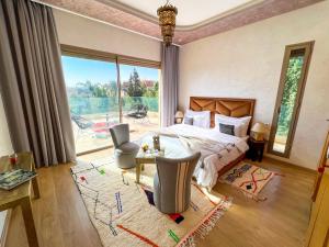 um quarto com uma cama e uma grande janela em Riad villa saphir & SPA em Marrakech