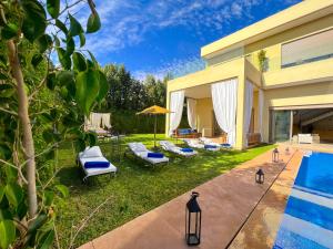 a backyard with a swimming pool and a house at Riad villa saphir & SPA in Marrakech