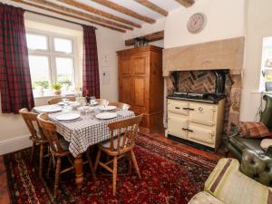 a dining room with a table and a fireplace at Quarry House in Whiston