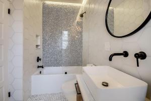 Baño blanco con bañera y lavamanos en 3 - 4 Bdrm Victorian Beach House, en Asbury Park
