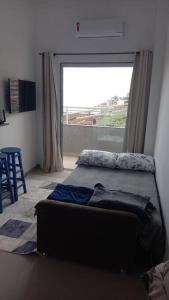 uma sala de estar com um sofá e uma grande janela em VidigalHouse apartamento Vista Mar 2 no Rio de Janeiro