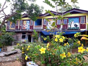 a house with flowers in front of it at Fatehah Inn in Kuala Tahan