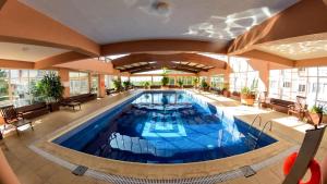 una piscina cubierta en un hotel con un gran edificio en Apto Centro de Gramado (2D c/Piscina Térmica) en Gramado