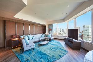 a living room with a couch and a tv at The Prince Park Tower Tokyo - Preferred Hotels & Resorts, LVX Collection in Tokyo