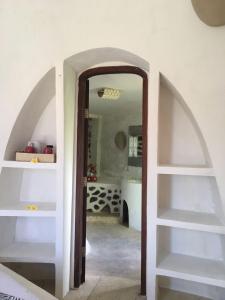 um corredor com um arco e uma parede branca em Villa Hopedome em Teluknarat