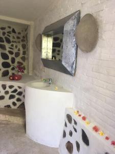 a bathroom with a sink and a cow print wall at Villa Cocodome in Teluk Nara