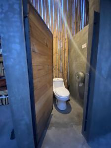 baño con aseo y puerta de madera en Fungi Tipis, en Tepoztlán