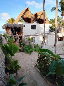 dom z dachem krytym strzechą na plaży w obiekcie Casa Mate BeachFront HOUSES El Cuyo w mieście El Cuyo