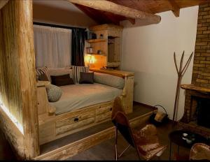 een slaapkamer met een houten bed in een kamer met een open haard bij Νύμφες Σαλέ Αλκυόνη 