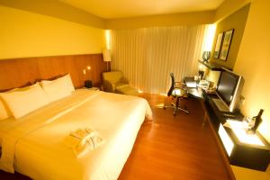 a hotel room with a large bed and a television at Pestana Caracas Premium City & Conference Hotel in Caracas +25 photos