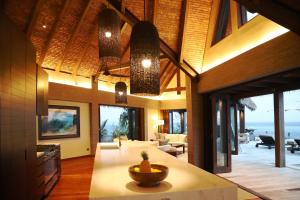 Villa Malolo Levu في مالولو: غرفة معيشة مع غرفة كبيرة مع طاولة