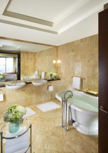 a large bathroom with three sinks and a tub at Mandarin Oriental Miami in Miami