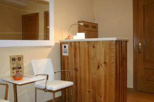 a room with a chair and a table and a mirror at Hostal Hispanico I in Salamanca