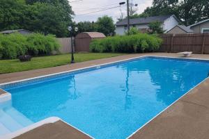 a swimming pool with blue water in a yard at 1349 Jennings court Private Pool, Fire pit, BBQ A FUN place to RELAX in Mason