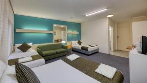 Habitación de hotel con sofá y sala de estar. en Silver Oaks Motel en Gilgandra