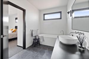uma casa de banho branca com uma banheira e um lavatório em Ruse Estate Retreat Margaret River em Rosa Glen