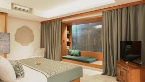 a bedroom with a bed and a tv and a window at Annora Villas Seminyak in Seminyak